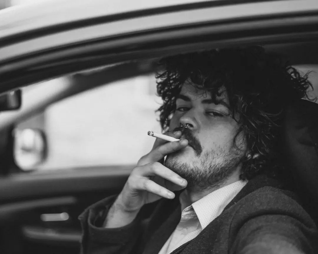 About 10 A Man Smoking a Cigarette in a Car